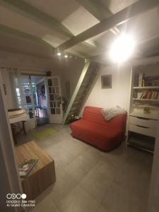 a living room with a red couch and a staircase at Chez Rodolphe in Le Tampon
