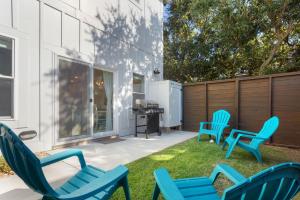 a patio with blue chairs and a grill at BCW32A - Sea Escape in Corolla