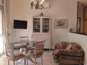 a living room with a table and chairs and a television at Appartamento silenzioso comodo alle spiagge e stazione ferroviaria in Lavagna