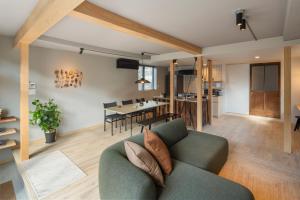 a living room with a green couch and a dining room at YAMO Nagiso in Nagiso