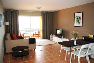 ein Wohnzimmer mit Sofa und Tisch in der Unterkunft Apartamento Bela Vista in Porto Santo