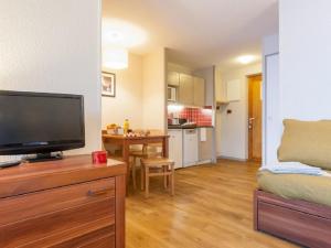 un soggiorno con una TV a schermo piatto su una cassettiera di Val Thorens - Appartements Ski aux Pieds au Cœur des Pistes a La Celle-sous-Gouzon Altre 17 foto