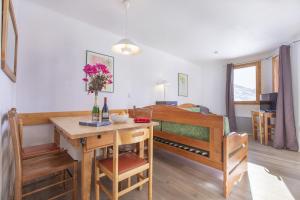 una stanza con un tavolo e un letto a castello di Val Thorens - Appartements Ski aux Pieds au Cœur des Pistes a La Celle-sous-Gouzon