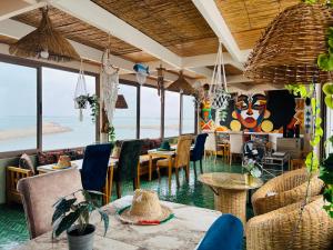 a restaurant with tables and chairs and a view of the ocean at Riad do artista space in El Jadida