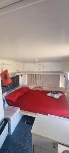 a large red bed in a small room at Unique night in a cozy caravan in Lezhë