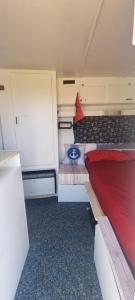 a small room with a bed and a keyboard at Unique night in a cozy caravan in Lezhë