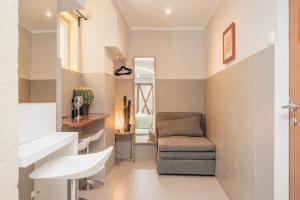 a bathroom with a chair and a sink at Downtown Typical by Hosty in Bicas
