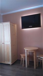 um quarto com uma mesa e uma televisão na parede em Pokoje gościnne u Krysi em Mizerna
