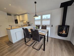 a living room with a table and a fireplace at Ostseeferienpark Walkyrien - Lotse j in Kagelbusch