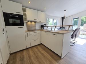 a kitchen with white cabinets and a refrigerator at Ostseeferienpark Walkyrien - Lotse j in Kagelbusch