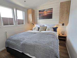 a bedroom with a large bed and two windows at Ostseeferienpark Walkyrien - Lotse j in Kagelbusch +20 photos