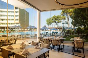a restaurant with tables and chairs and a pool at AluaSoul Sunny Beach - Adults Only - All Inclusive in Sunny Beach +84 photos