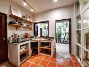 a kitchen with an orange tiled floor and windows at Mi Casa Pool Villa Hua Hin in Hua Hin