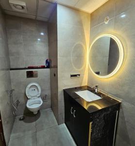 a bathroom with a toilet and a sink and a mirror at The Elite Ohana in Lucknow +4 photos