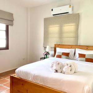 una camera da letto con un letto con due animali di peluche sopra di Cozy Pool Villa Hua Hin a Hua Hin