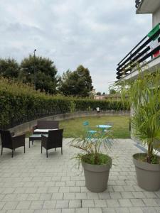 a patio with a table and chairs and plants at La Casa di Manu in Lessona
