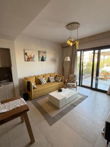 a living room with a couch and a table at ElGouna, Elegant 1Bedroom, private patio in Fanadir Marina in Hurghada