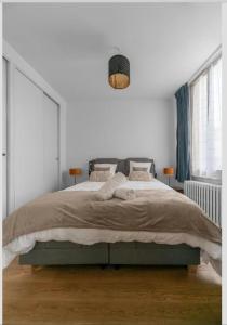 une chambre avec un grand lit dans une pièce blanche dans l'établissement LE DARCET - Hypercentre - Calme - Proche Gare & Thermes, à Vichy