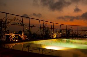 a fence around a pool with a sunset in the background at Hotel Boutique Xiqué in Brisas de Zicatela