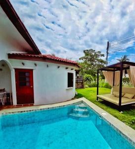 una villa con piscina accanto a una casa di Cozy Pool Villa Hua Hin a Hua Hin