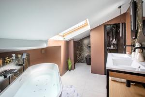 Un baño con dos lavabos y una bañera. en Suite Choco Love and SPA, en Belfort
