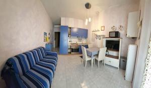een woonkamer met een blauwe bank en een keuken bij Girasole in Parma