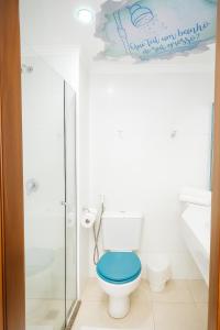 a bathroom with a toilet with a blue seat at Hotel Dan Inn São Carlos By Nacional Inn in São Carlos