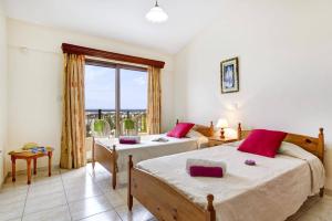 a bedroom with two beds and a window at Villa Antonia by Villa Plus in Peyia +13 photos