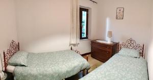 a bedroom with two beds and a dresser and a window at A casa mia in Santa Maria degli Angeli