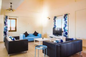 a living room with two couches and a tv at Villa Antonia by Villa Plus in Peyia