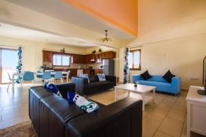 a living room with a couch and a table at Villa Antonia by Villa Plus in Peyia