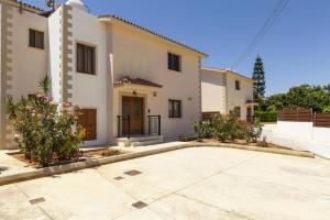 a large white house with a driveway at Villa Antonia by Villa Plus in Peyia