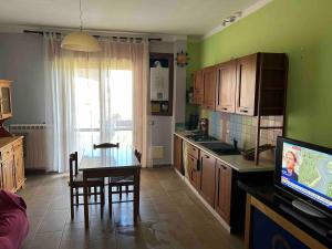 a kitchen with a table and a kitchen with green walls at Rose Irpinia Home in Montemarano