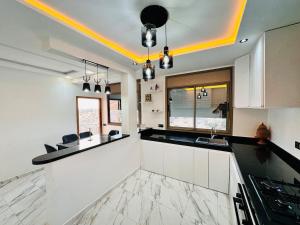a kitchen with white cabinets and black counter tops at Happy Monkey Villa Taghazout in Aït Ahmed