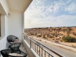 a balcony with two chairs and a view of the desert at Happy Monkey Villa Taghazout in Aït Ahmed
