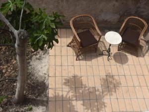 a patio with two wicker chairs and a table at Cal Teixidor in Mediona