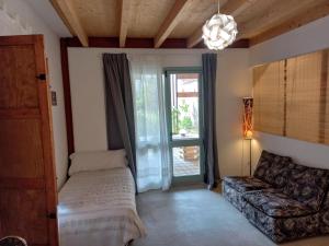 ein Schlafzimmer mit einem Bett und einer Couch und einem Fenster in der Unterkunft Cal Teixidor in Mediona