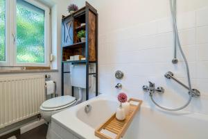 a bathroom with a white tub and a toilet at EG M City Wohnung nähe Salzburg in Freilassing