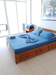 a bed with a blue blanket on top of it at Apartamento Caribbean Tucacas in Tucacas