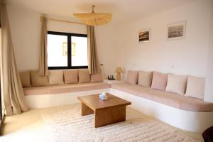 a living room with a couch and a coffee table at Surf and Friends in Tamraght Oufella
