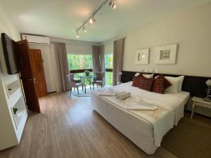 ジャラグァー・ド・スーにあるHotel Fazenda Vale das Pedrasの大きなベッドとテーブルのある寝室 +66枚の写真