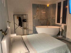 a bathroom with a bath tub and a bed at Suite Calliope By Lovers In Fiuggi in Fiuggi
