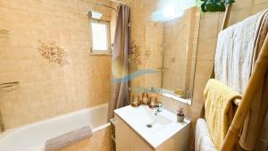 a bathroom with a sink and a tub and a shower at Casa Tropical by Sunny Deluxe in Armação de Pêra +12 photos