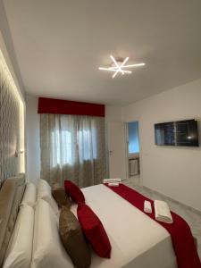 a bedroom with a large white bed with red pillows at Safa Venice Station in Mestre