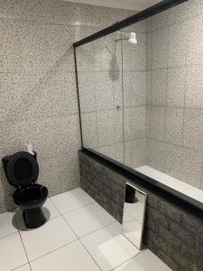 a bathroom with a black toilet and a mirror at Pousada Mirante Da Guariba in Angra dos Reis +28 photos
