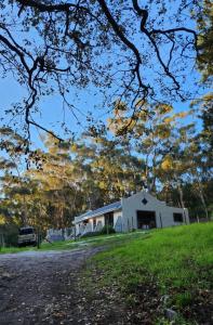 una casa bianca in mezzo a un campo di Concordia Kloof Cottage a Baardskeerdersbos
