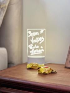 a table with a chalkboard and a piece of food on it at Hospedagem Inclusiva - Quarto privado com banheiro in Rio de Janeiro