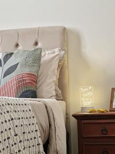 a bed with a pillow and a wooden night stand at Hospedagem Inclusiva - Quarto privado com banheiro in Rio de Janeiro