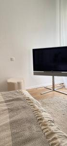a living room with a flat screen tv and a bed at Gemütlich Wohnen in Hochheim - eigener Tiefgaragenparkplatz in Hochheim am Main