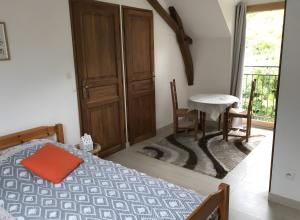 una camera da letto con un letto, un tavolo e una finestra di Appartement à l'Aujardière a Durtal